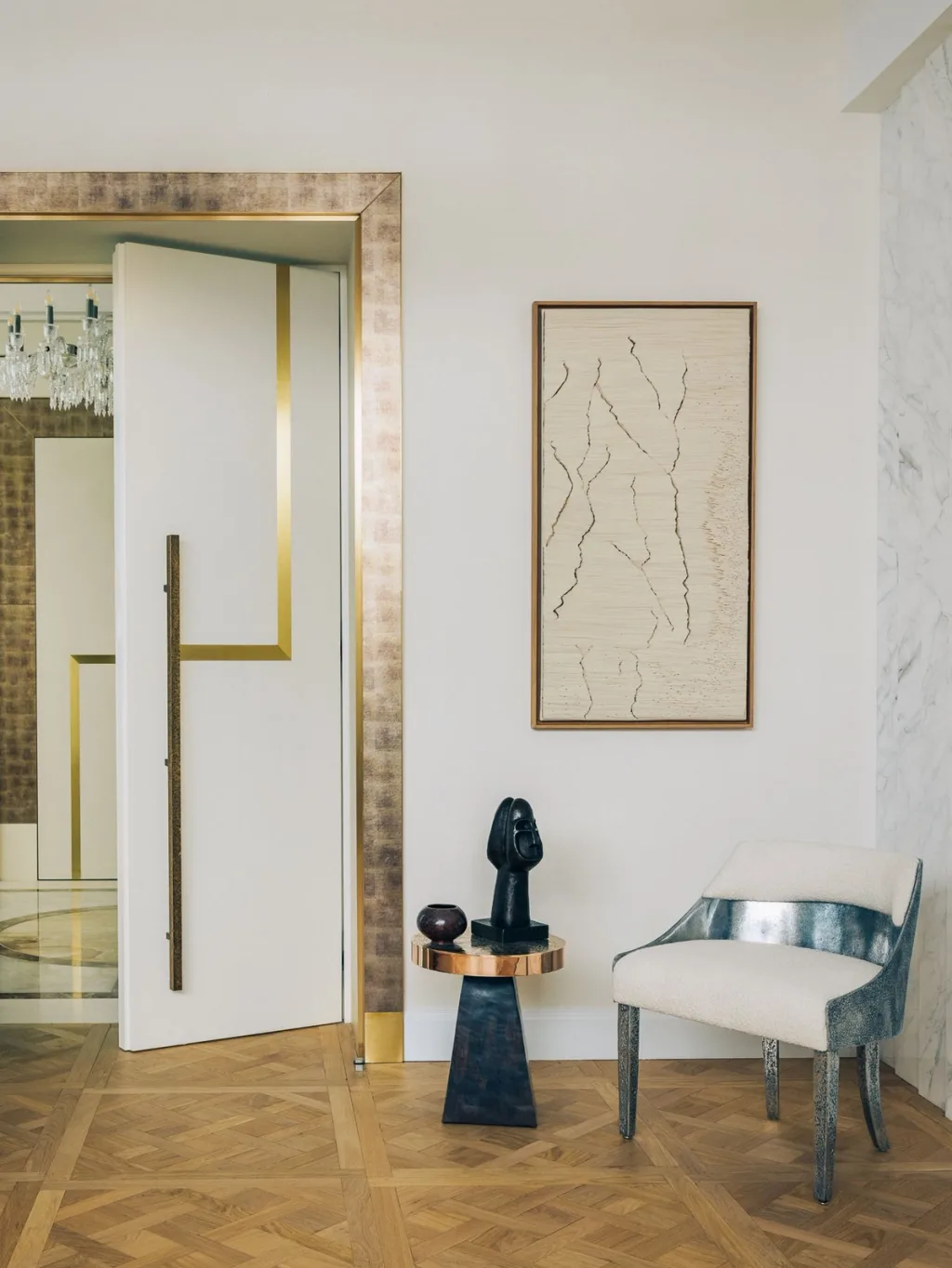 Silver-toned chair and small sculptural table beside a doorway in a Stéphanie Coutas interior, Paris