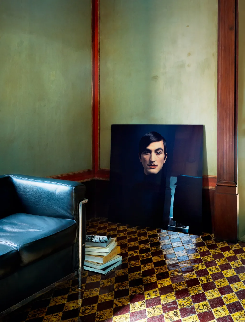 Dark sofa and a leaning portrait on a checkerboard floor in the Antonio G. Martiniello project, Naples