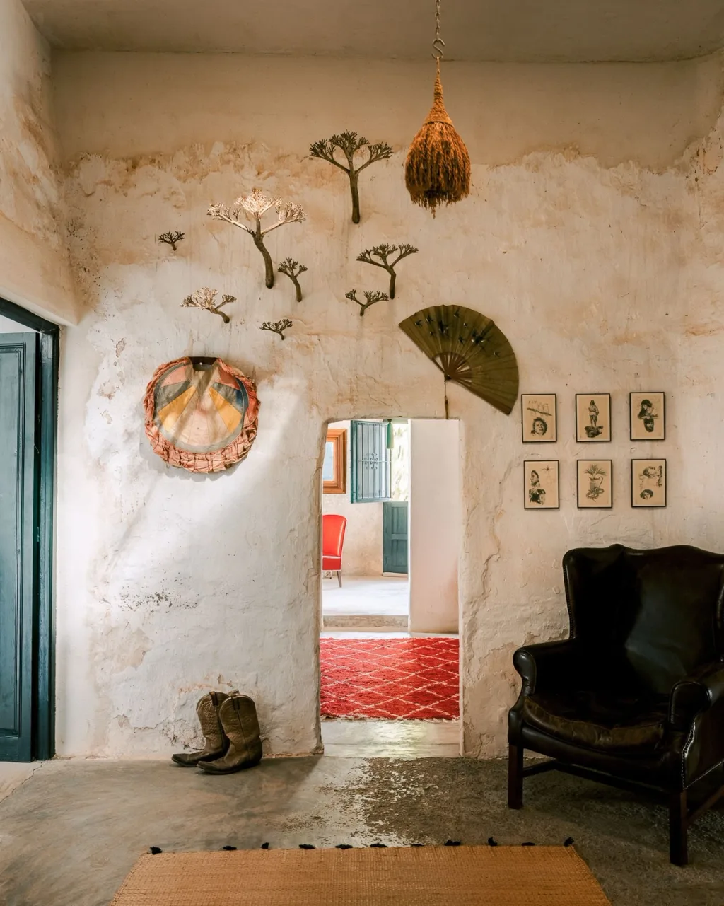 Dried botanical decorations above a narrow doorway beside a dark armchair in an Almeria home