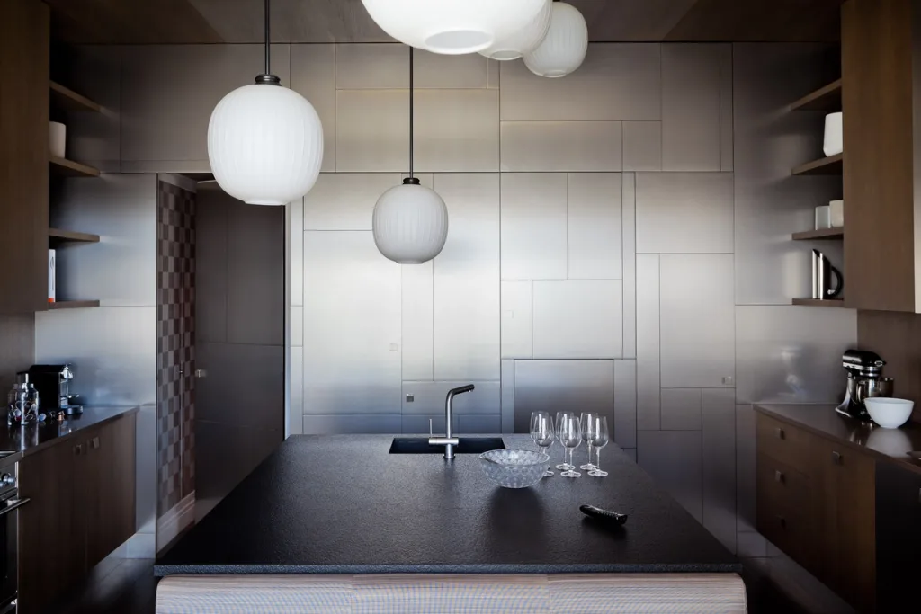 Dark kitchen island facing geometric metallic cabinet doors, Jean Louis Deniot, Paris