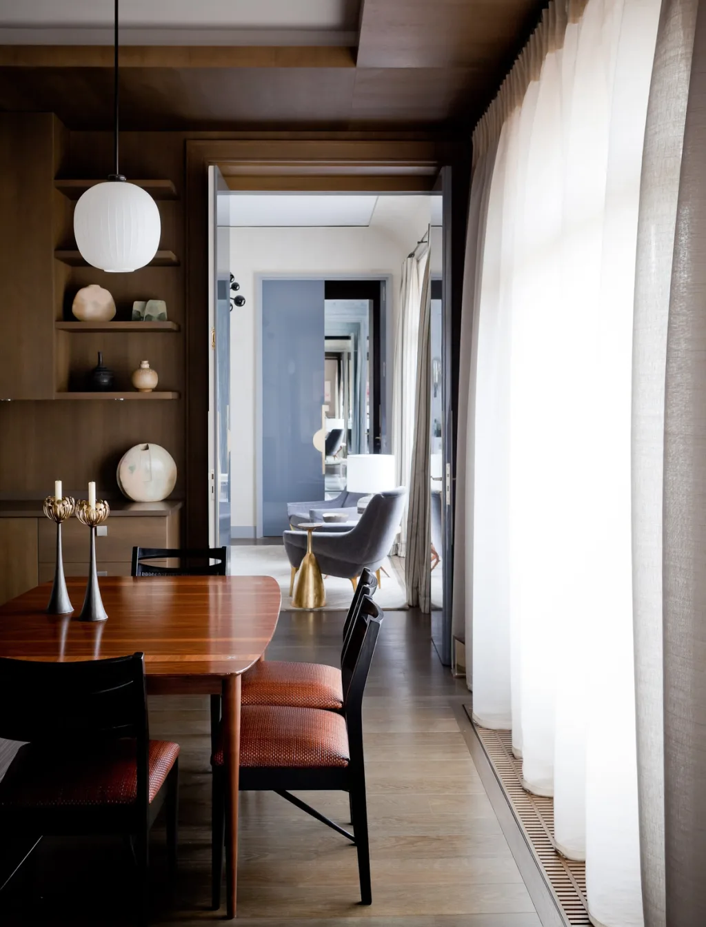 Dining table beside sheer curtains with a view through aligned doorways, Jean Louis Deniot, Paris