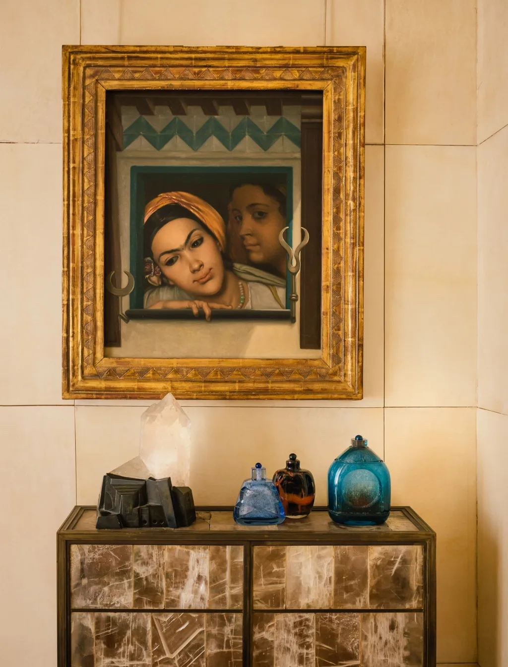 Colourful glass bottles on a cabinet beneath a framed double portrait, Felix Marcilhac series, Paris