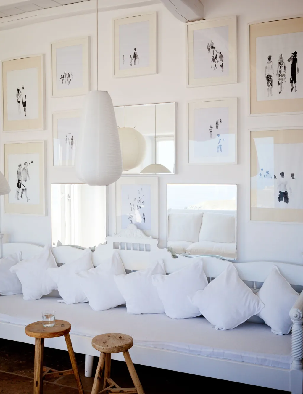 Sheer canopy curtains cross over a bed with a straw hat, a hotel in Mykonos