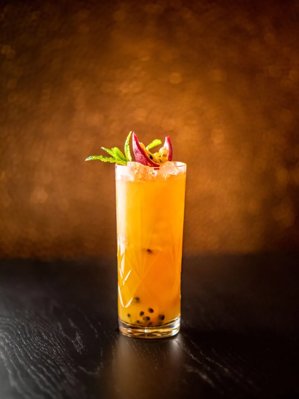 Orange cocktail with passion fruit and mint garnish for Cyril Lignac’s Saisons cookbook