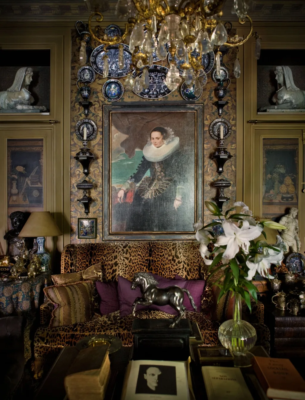 Portrait and blue plates above an animal-print sofa with purple cushions, Pierre Bergé, Paris
