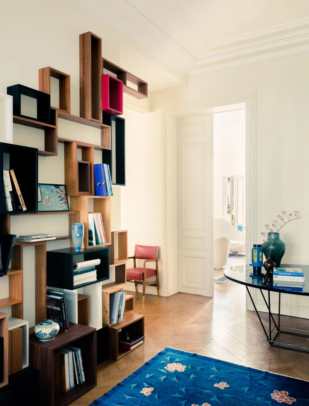 Irregular wooden box shelving beside a doorway and blue floral rug, Dimore Studio, Paris