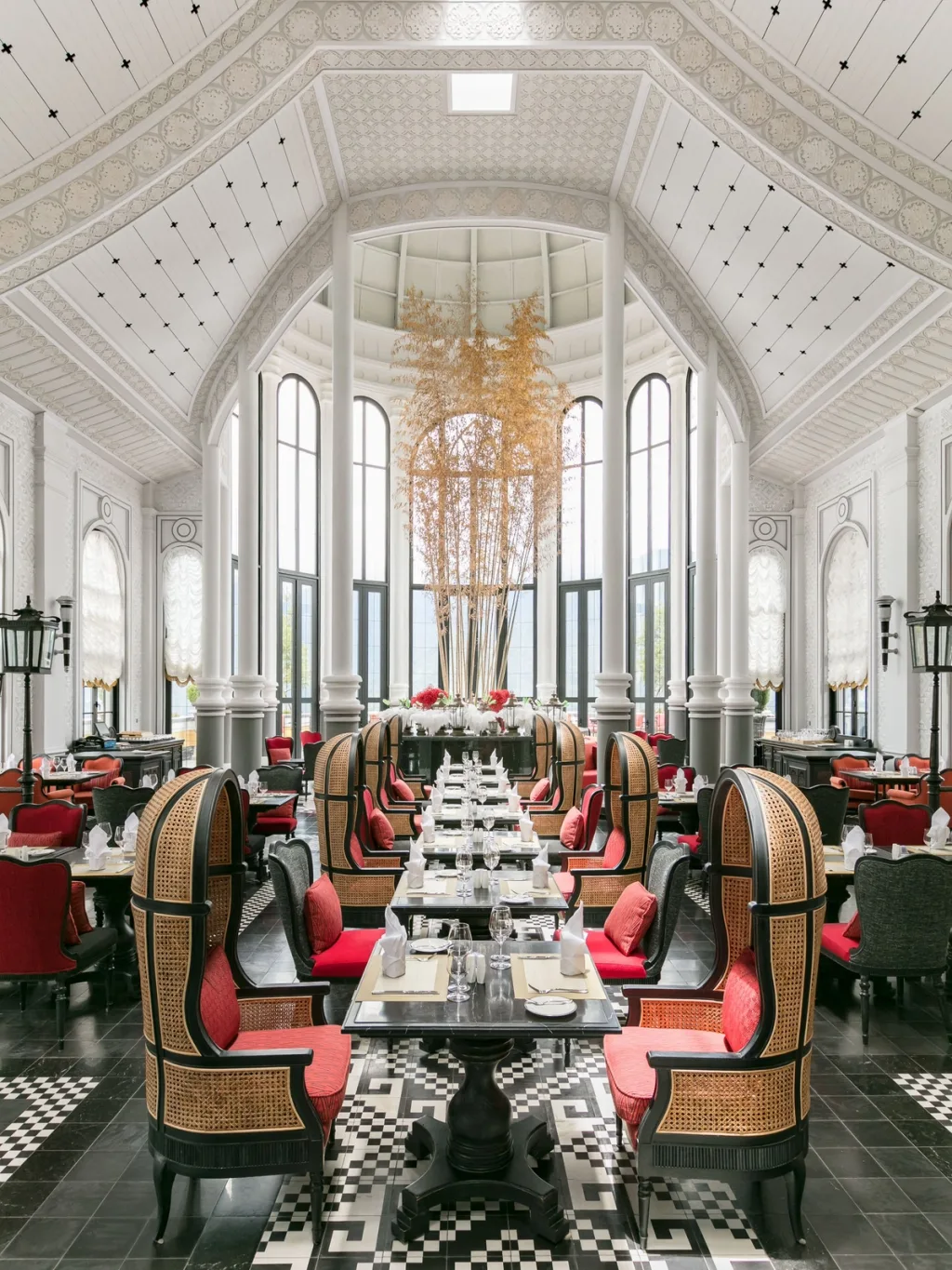 Cane peacock chairs around dining tables under a vaulted glass ceiling, Hotel de la Coupole MGallery, Sapa, Vietnam