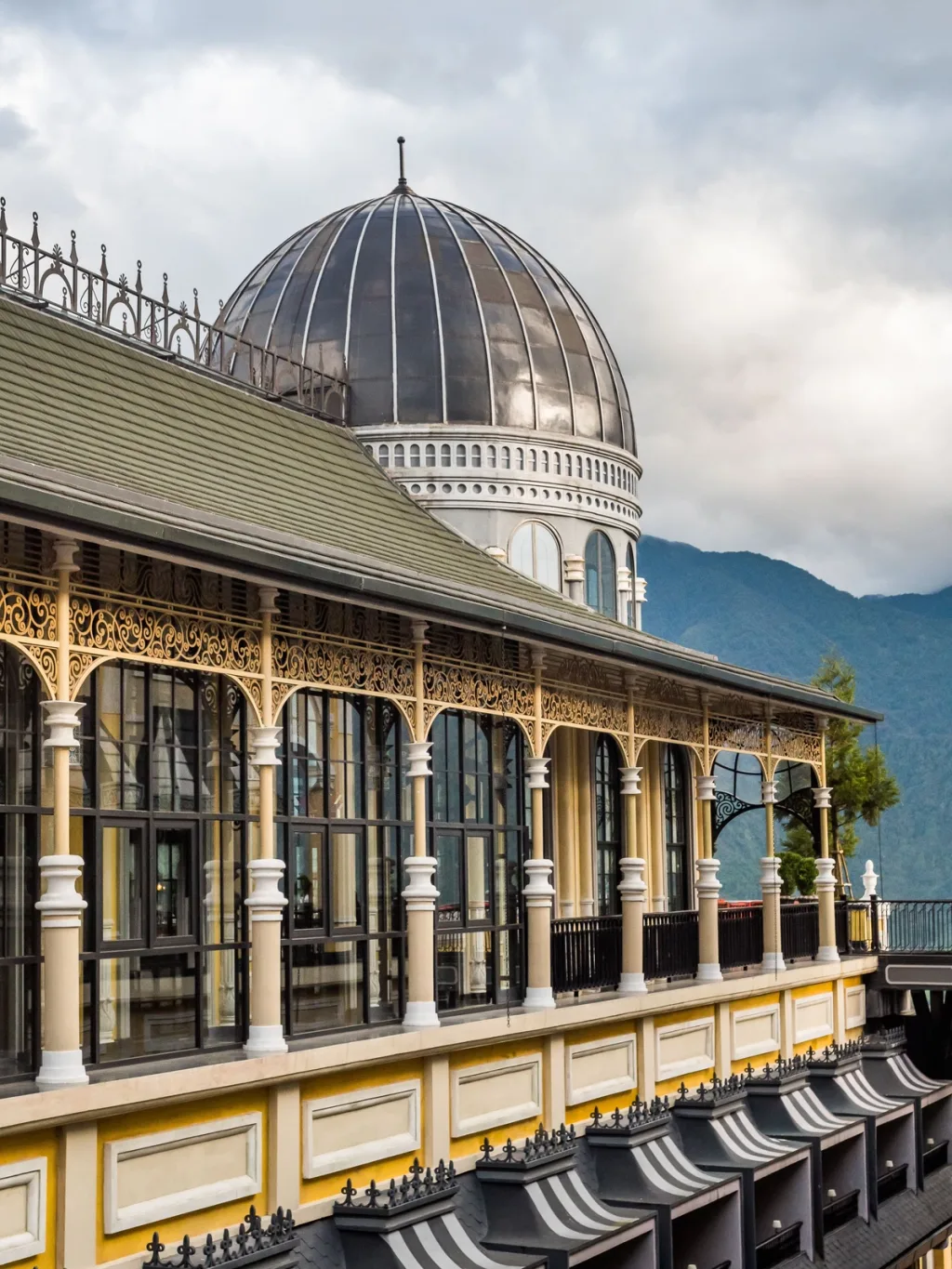 Dome roof and wrought-iron balconies against misty mountains, Hotel de la Coupole MGallery, Sapa, Vietnam
