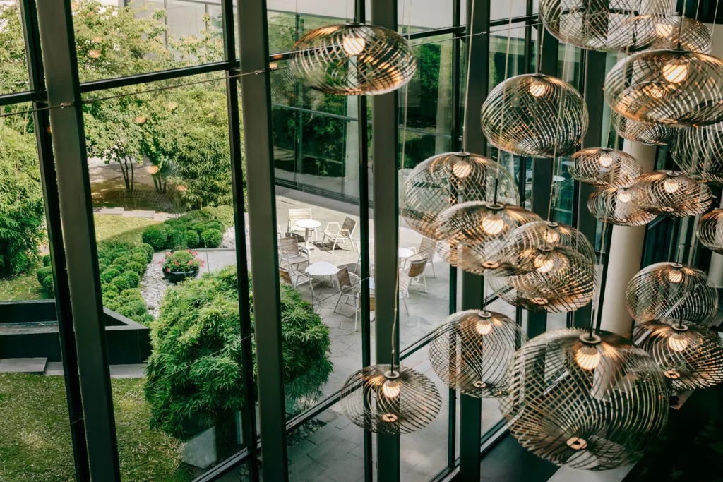 Woven pendant lamps against glass walls overlooking the courtyard, Pullman Bercy hotel