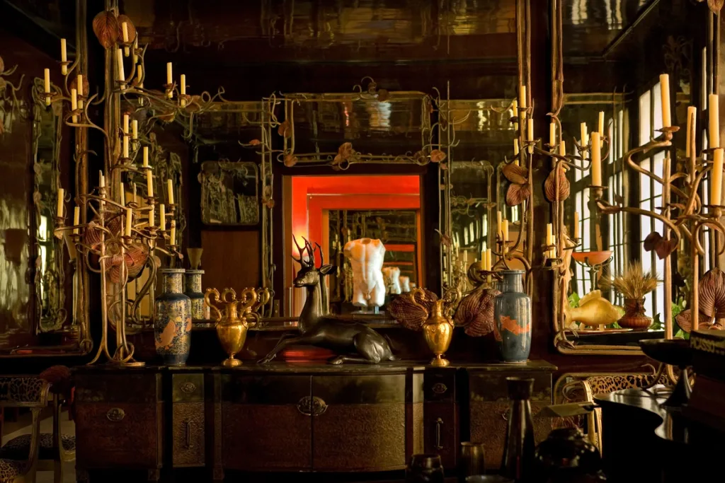 Tall branching candleholders and animal sculptures in a mirrored room, Yves Saint Laurent, Paris