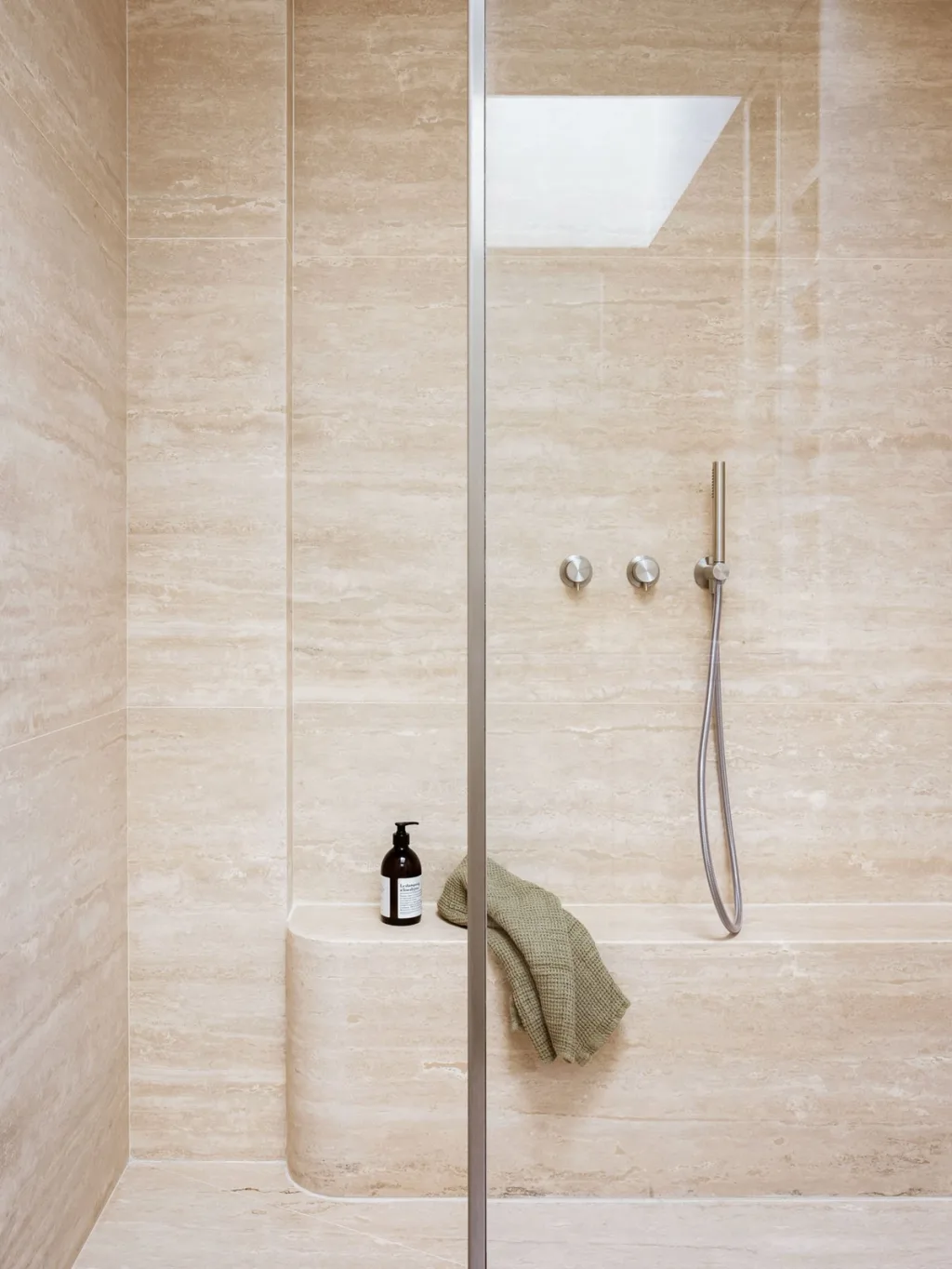 Pale shower with a built-in bench and glass screen in Hugues de Blignières' Paris interior