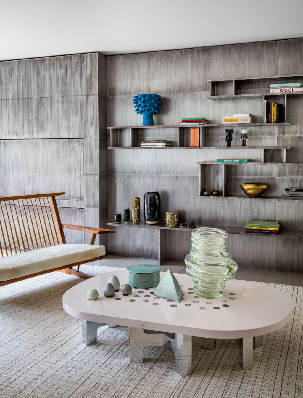 Low white table with sculptural objects before recessed display shelves, Olivier Dwek, Paris