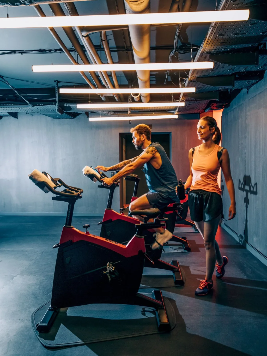 Guests cycling and walking through the industrial-style gym, Pullman Bercy hotel