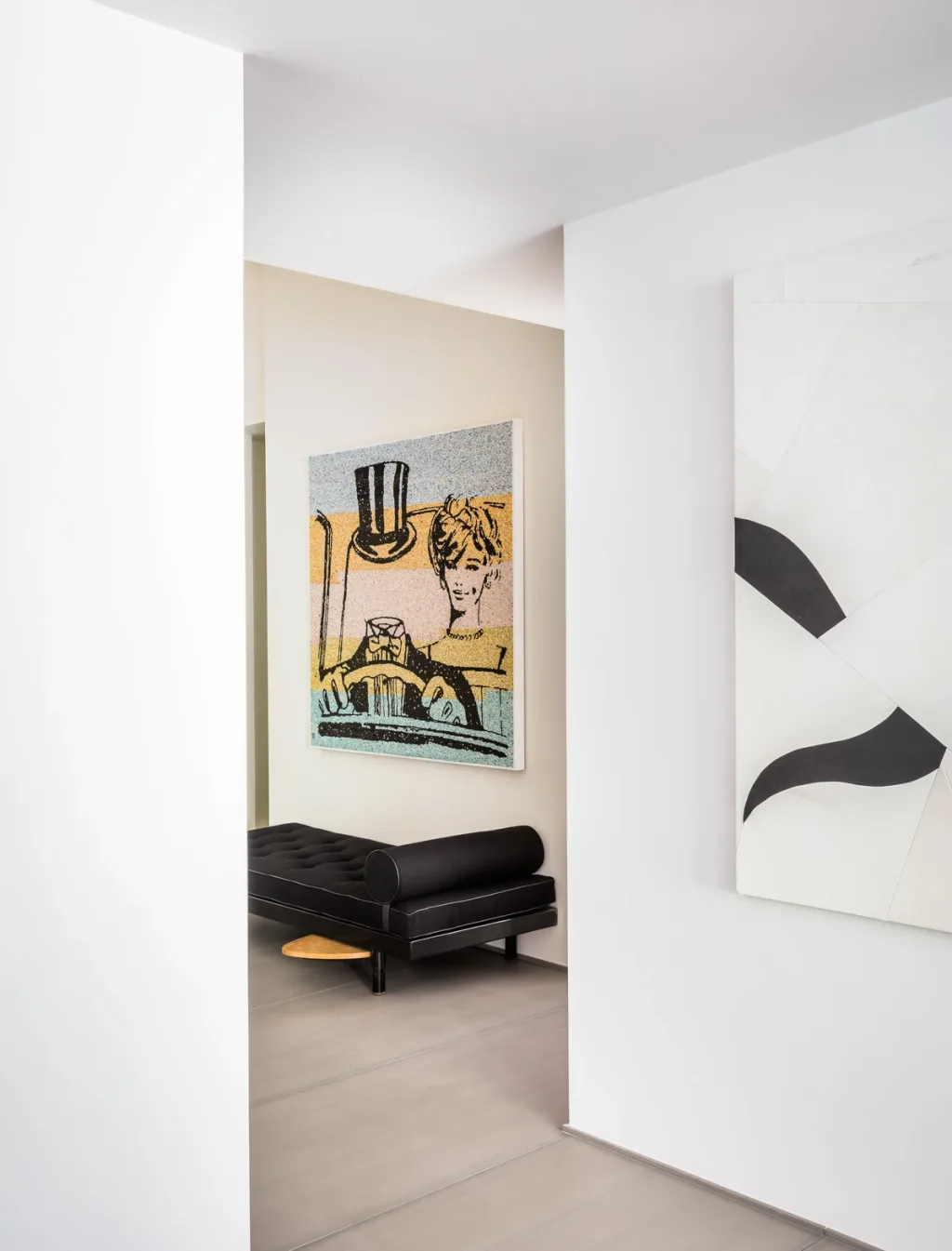 White art-lined passage revealing a black daybed in the next room, Olivier Dwek, Paris