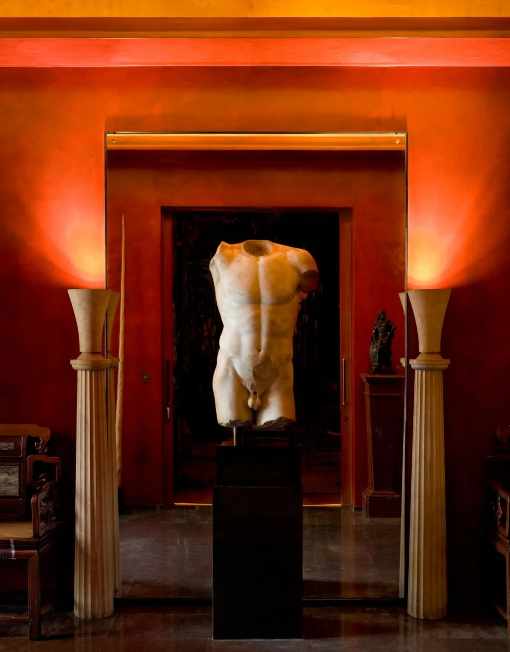Sculpted torso on a pedestal framed by glowing red doorways, Yves Saint Laurent, Paris