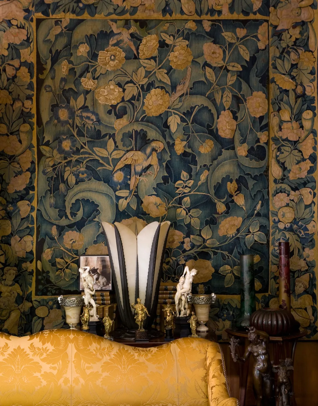 Floral tapestry, tall vase and small figures above a golden sofa, Yves Saint Laurent, Paris