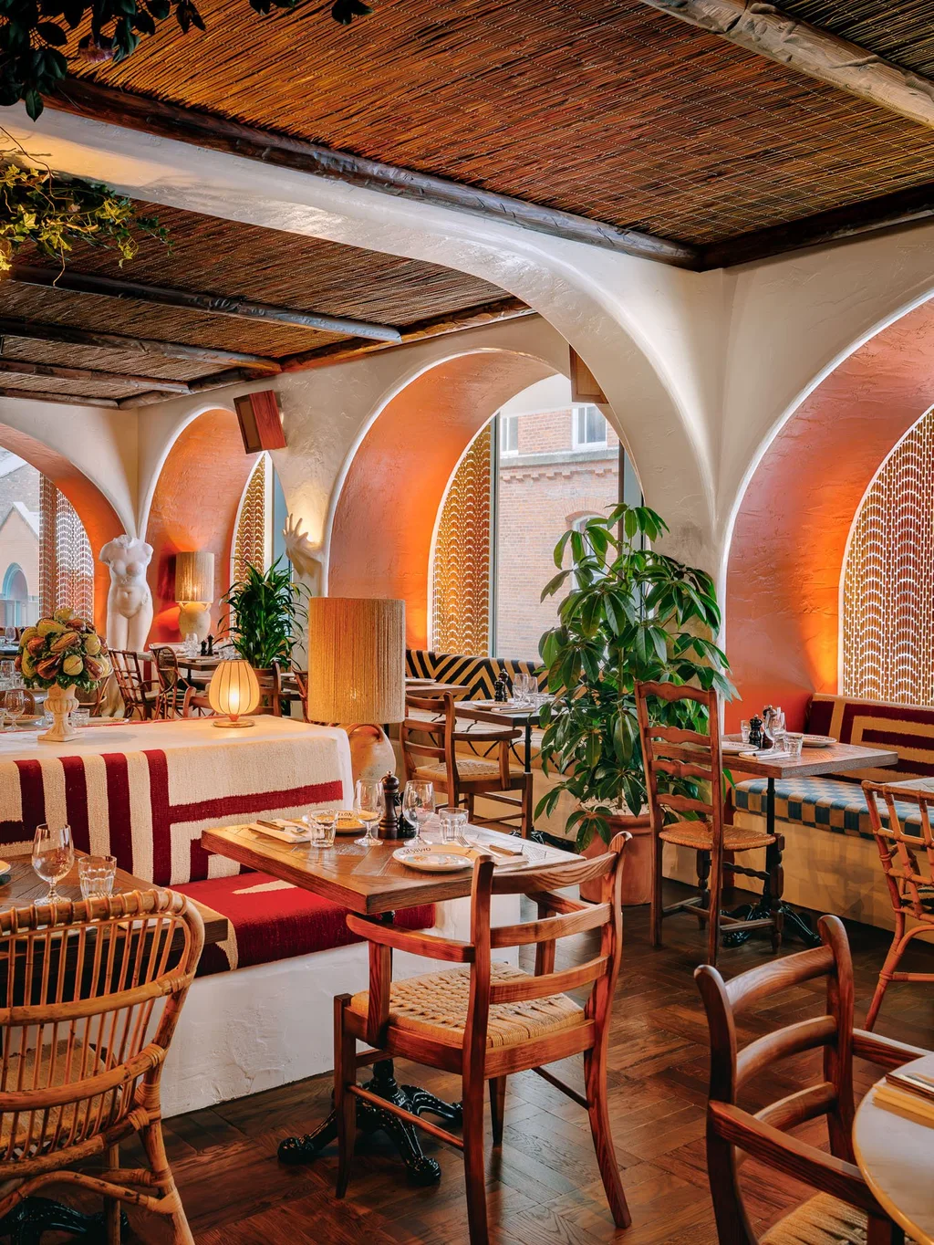 White arches, orange window recesses and striped banquettes at Big Mamma, UK