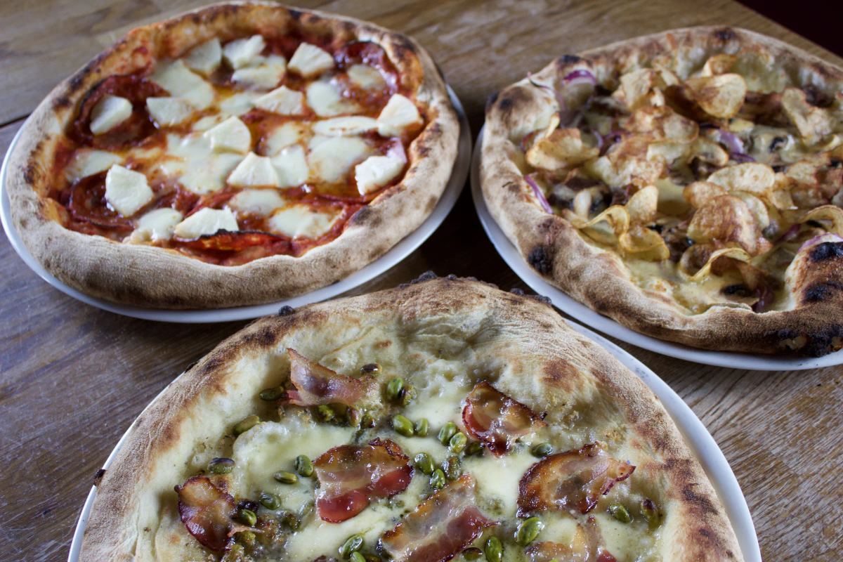 Þrjár pizzur á borði