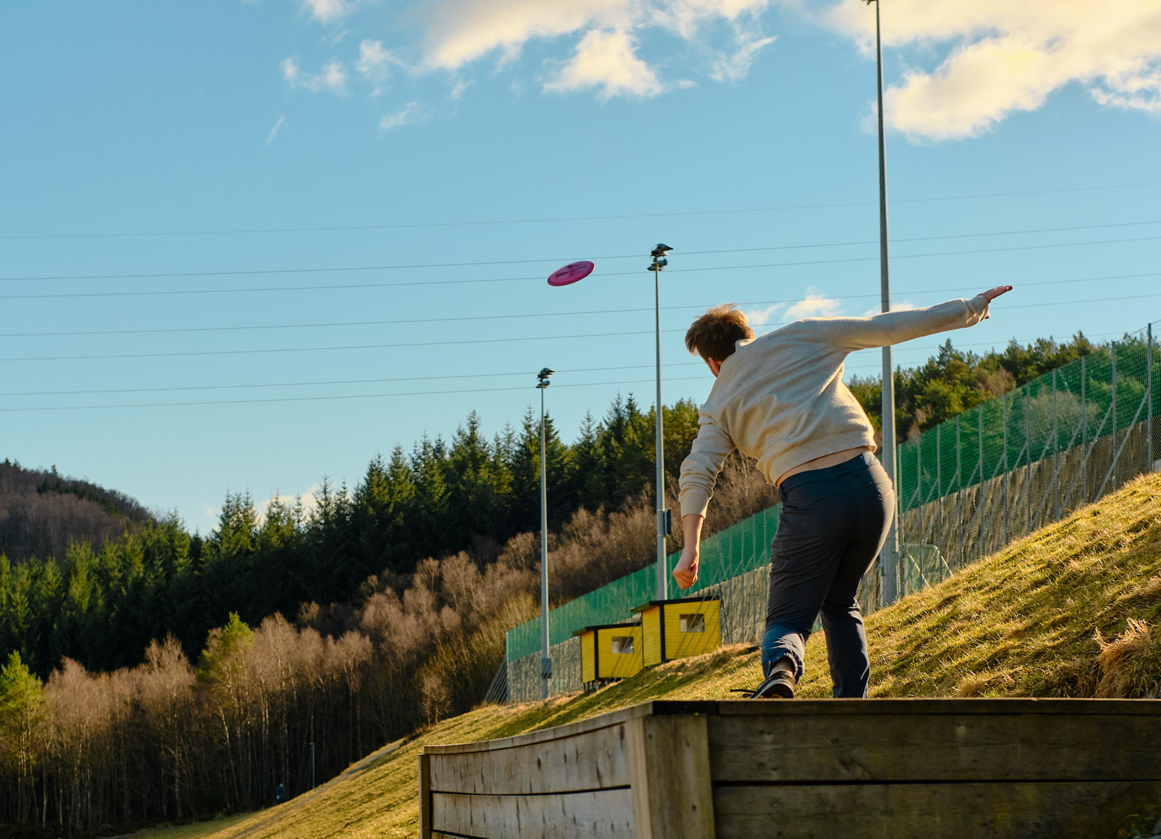 Man throwing out his sholder throwing a frisbee disc at Flaktveit