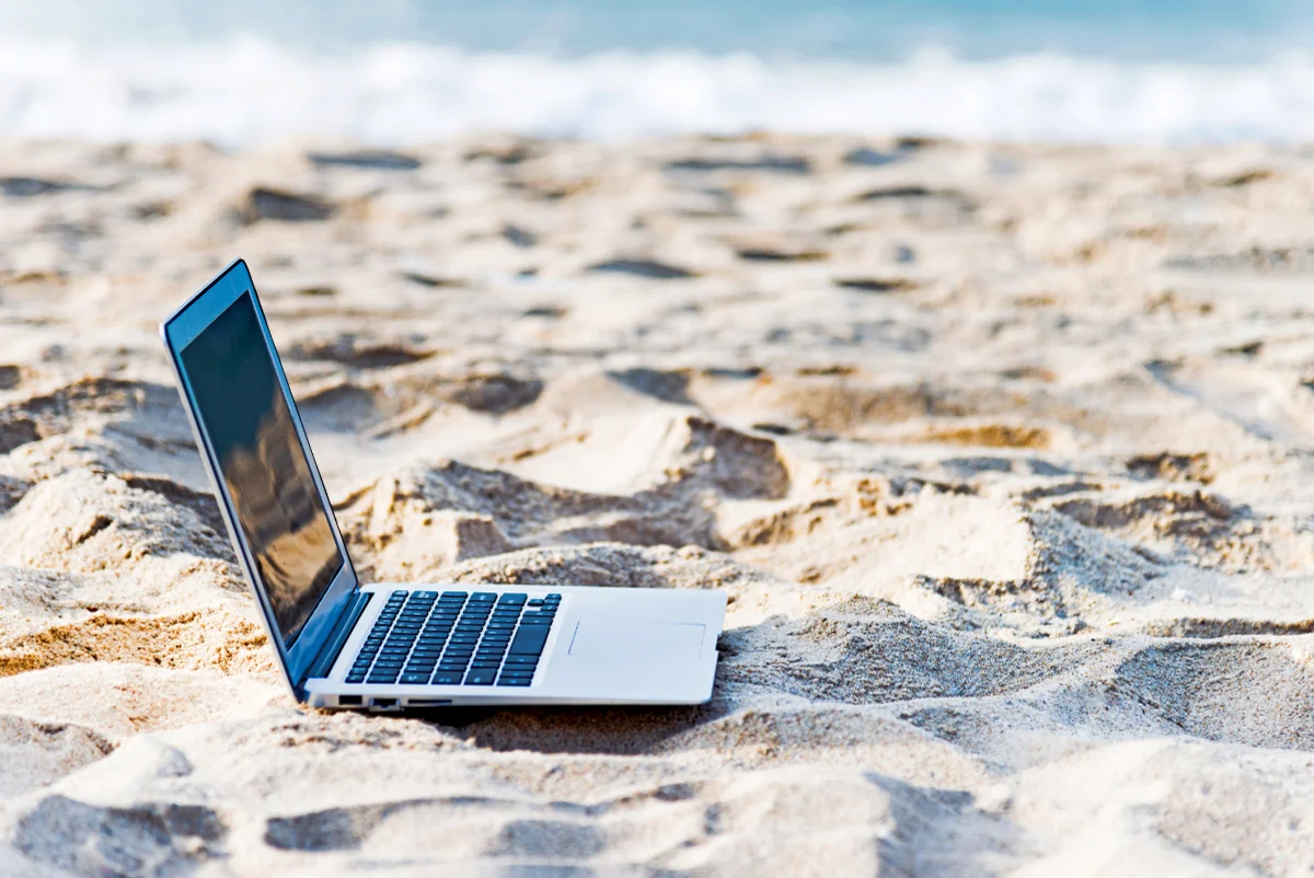 ordinateur portable ouvert sur une plage de sable 