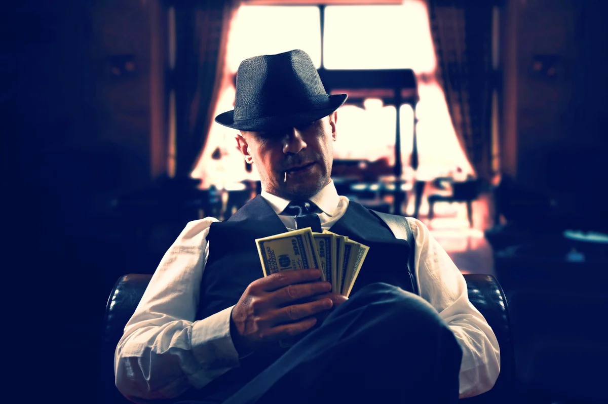 homme mafieux avec des billets dans la main