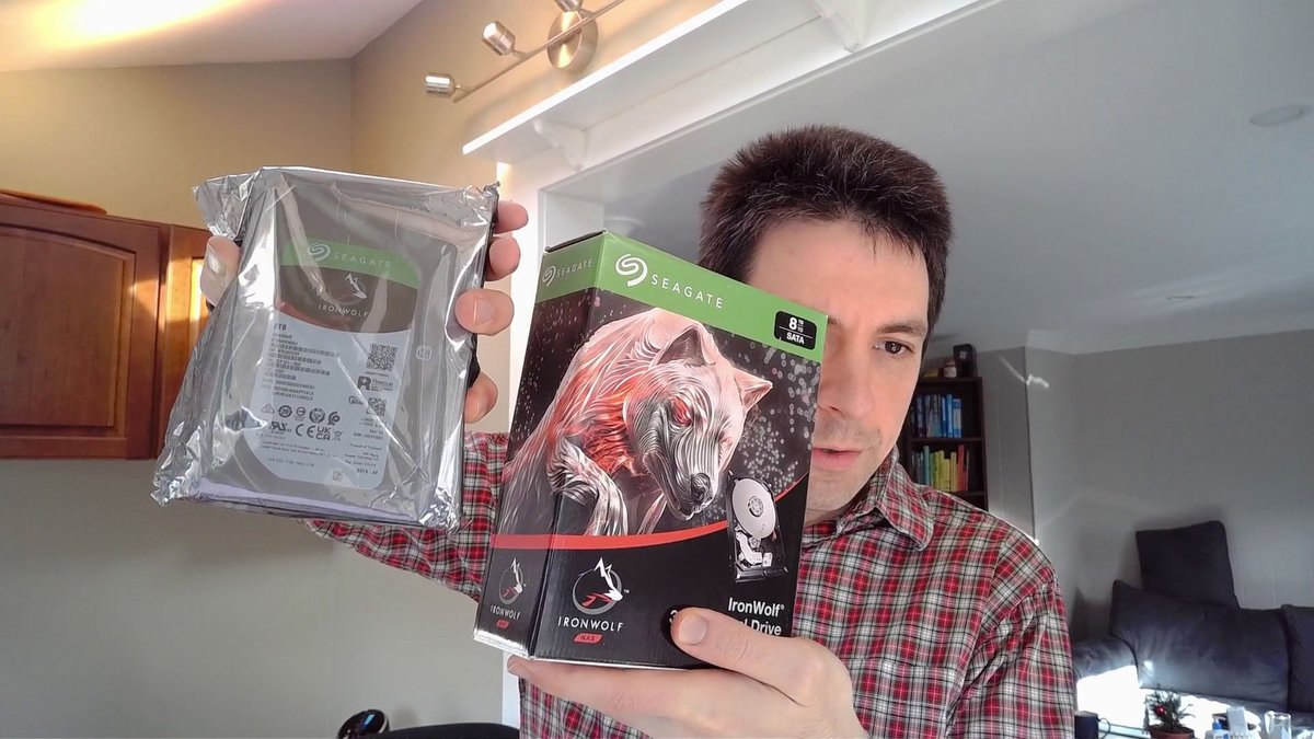 Photo of me holding Seagate IronWolf drives with different packaging
