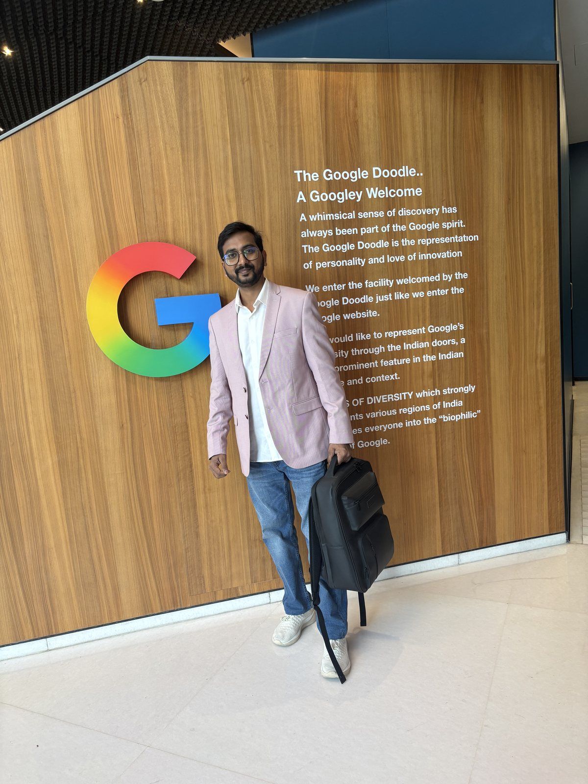 Suraj Shrivastava at the Google welcome wall, with the Google logo and "A Googley Welcome" doodle note behind him.
