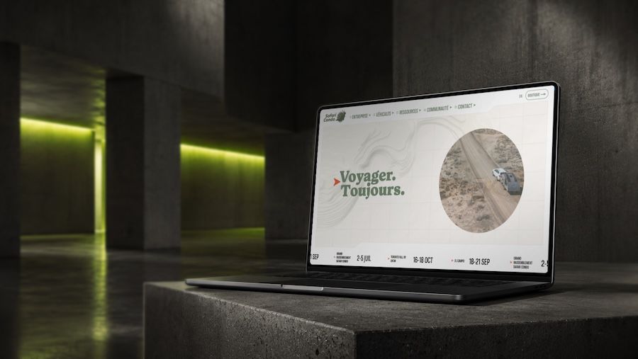 Laptop showing a travel website with text 'Voyager. Toujours.' and an image of a car on a dirt road.