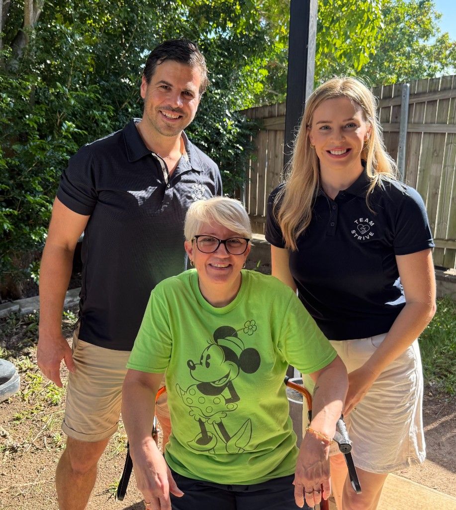 Two Team Strive support workers with a participant outdoors