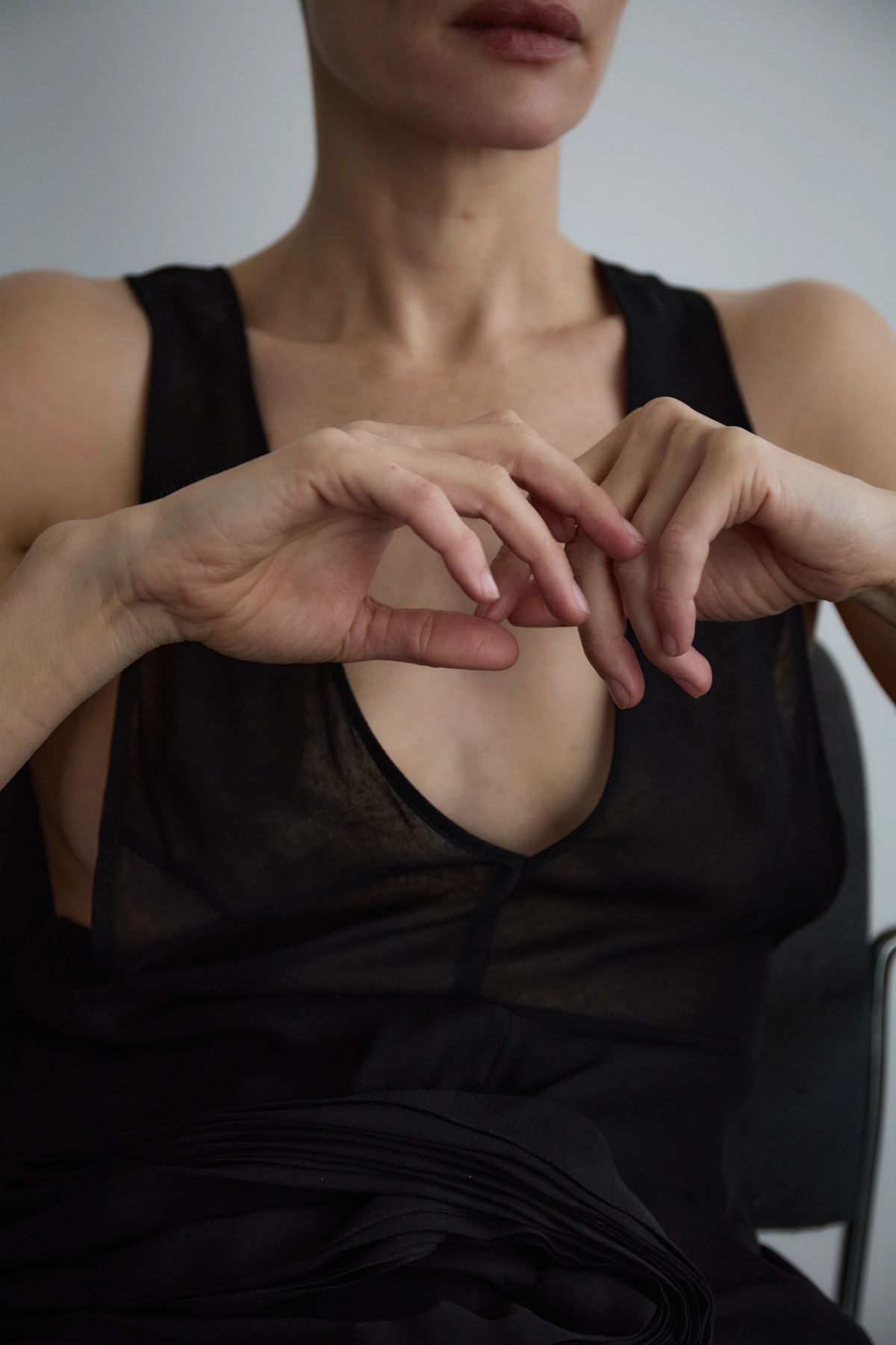 Model in sheer black top with hands up