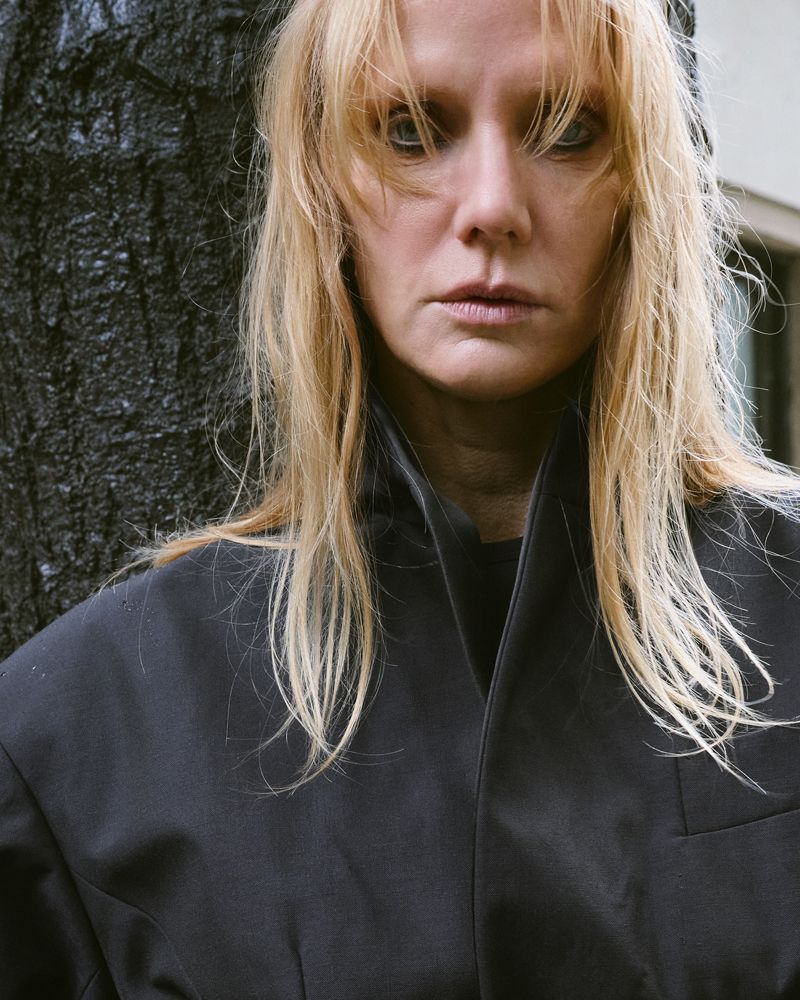 women with wet blonde hair standing by a tree