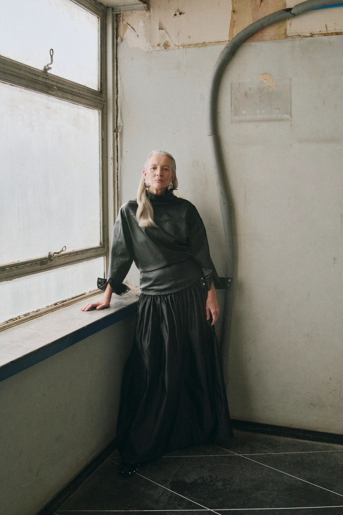 Women standing next to a window wearing black leather