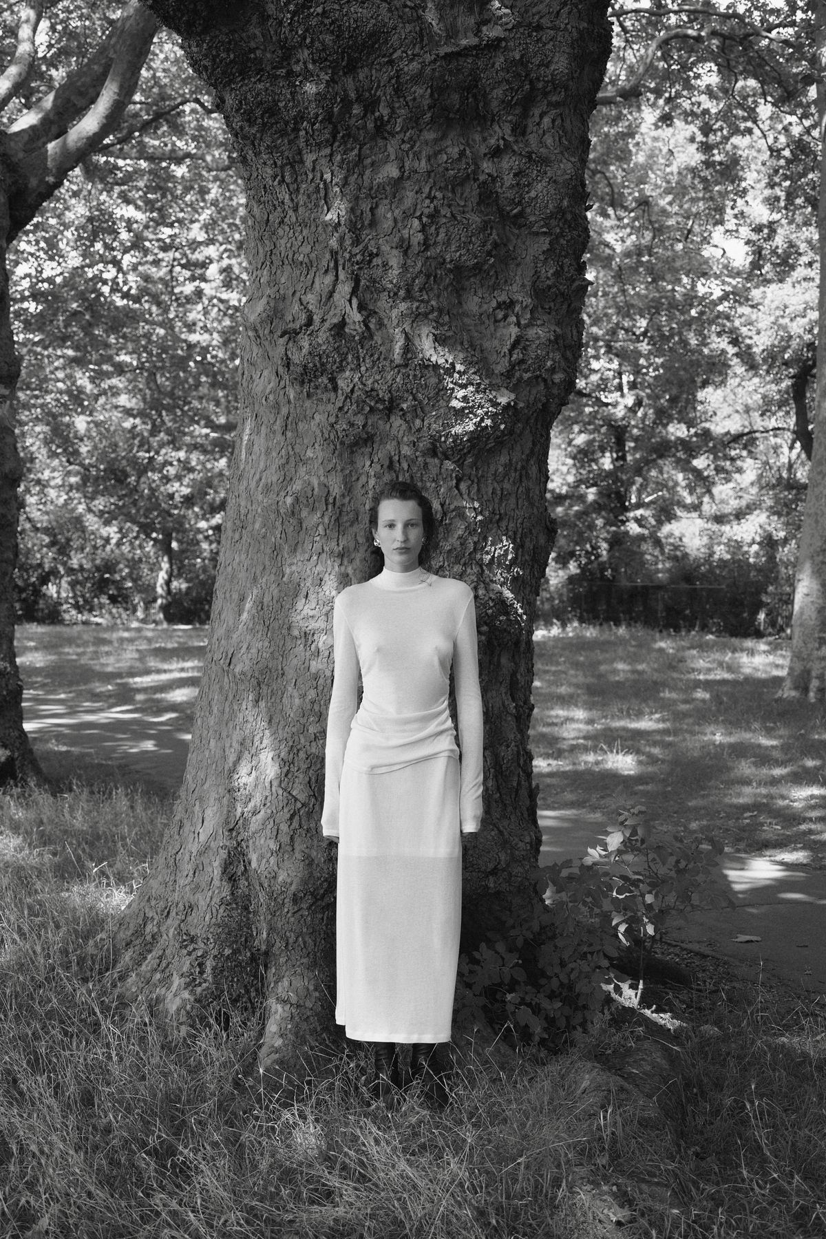 Woman standing by tree wearing all white