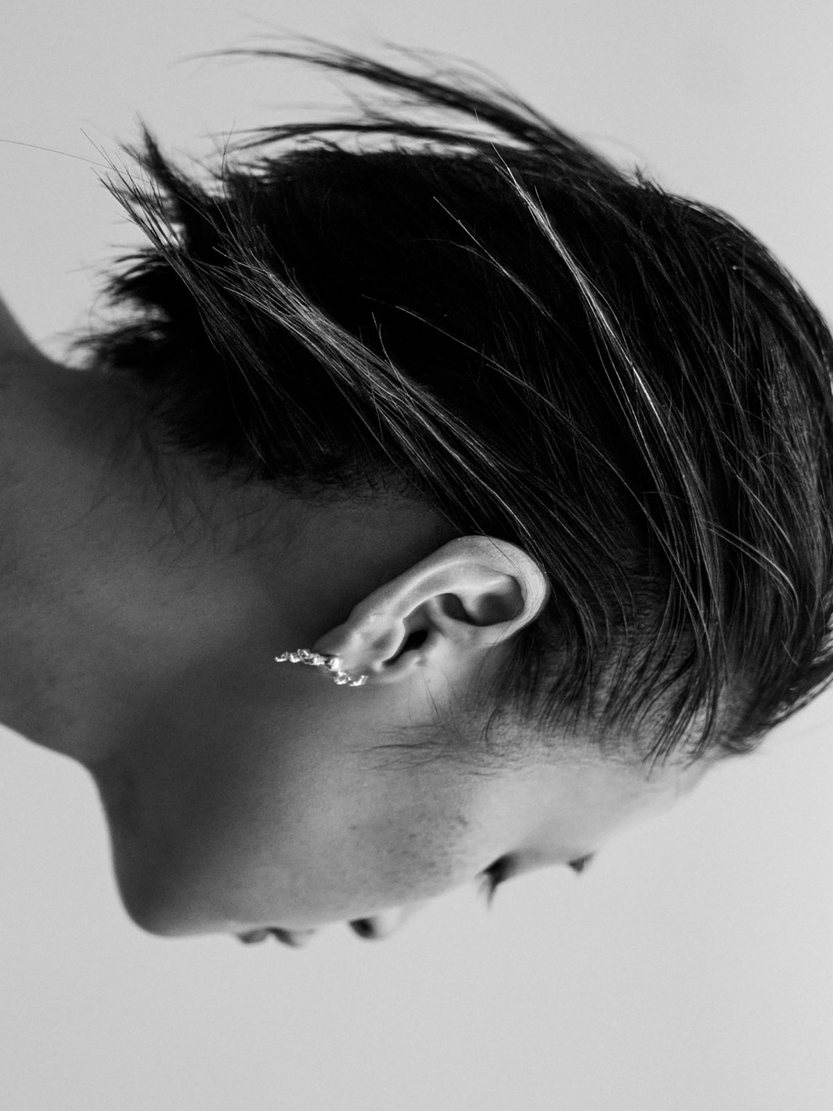 profile of women with black bob wearing an earring