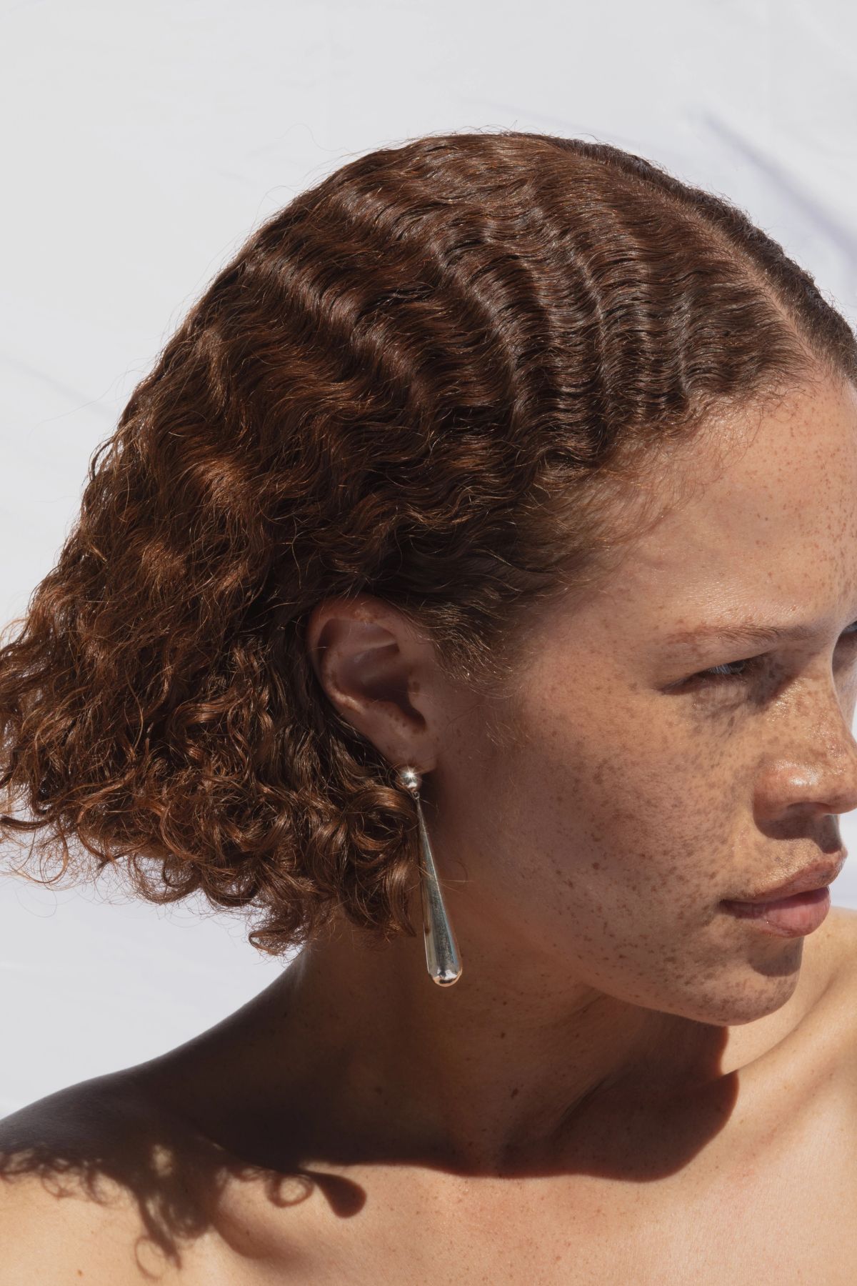 Cropped image of woen with bob and silver earrings