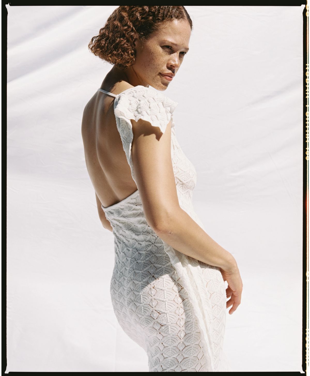 women with back to camera wearing a white backless dress