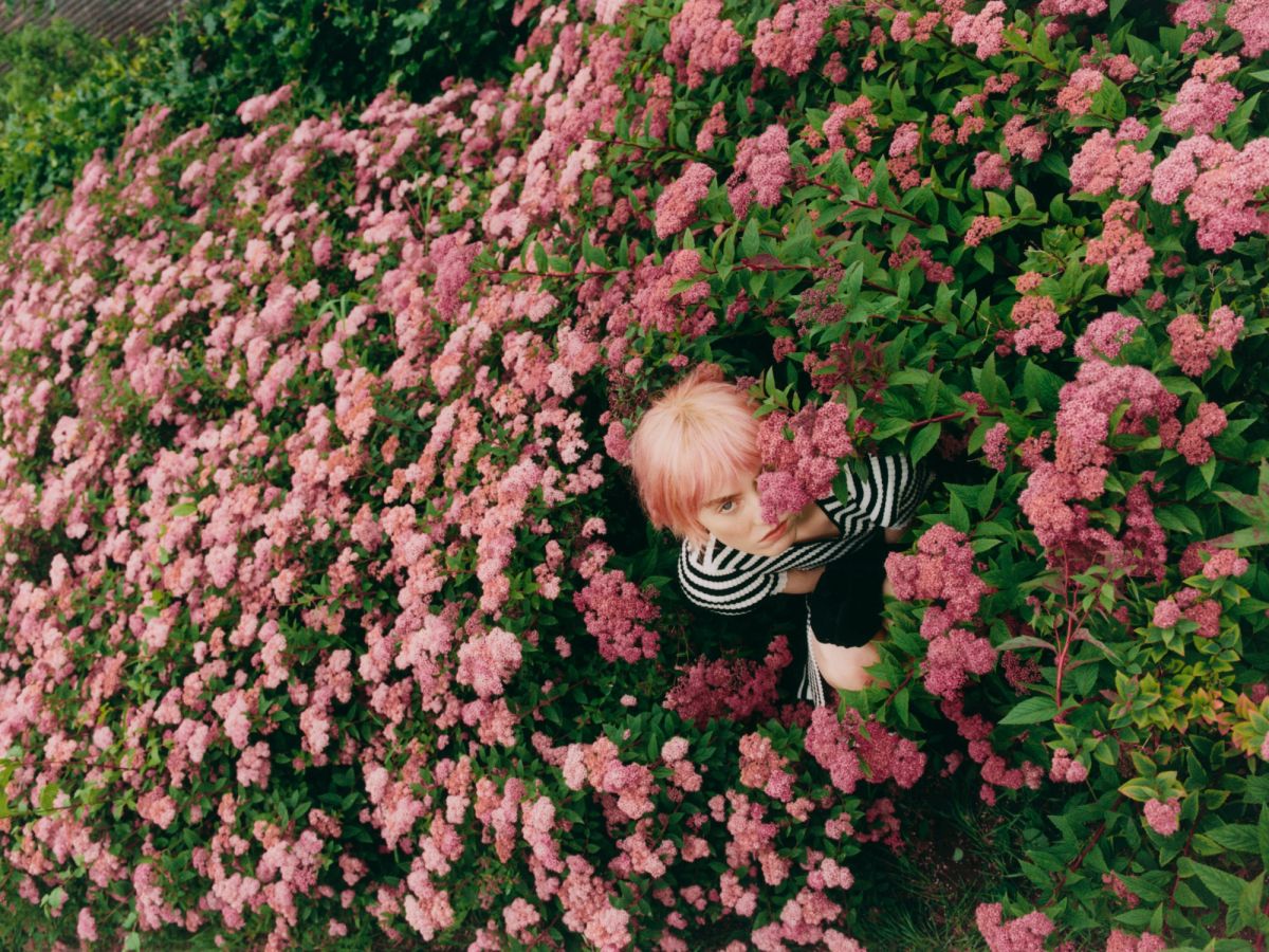 Women hiding in pink flowers wearing black and white stripes