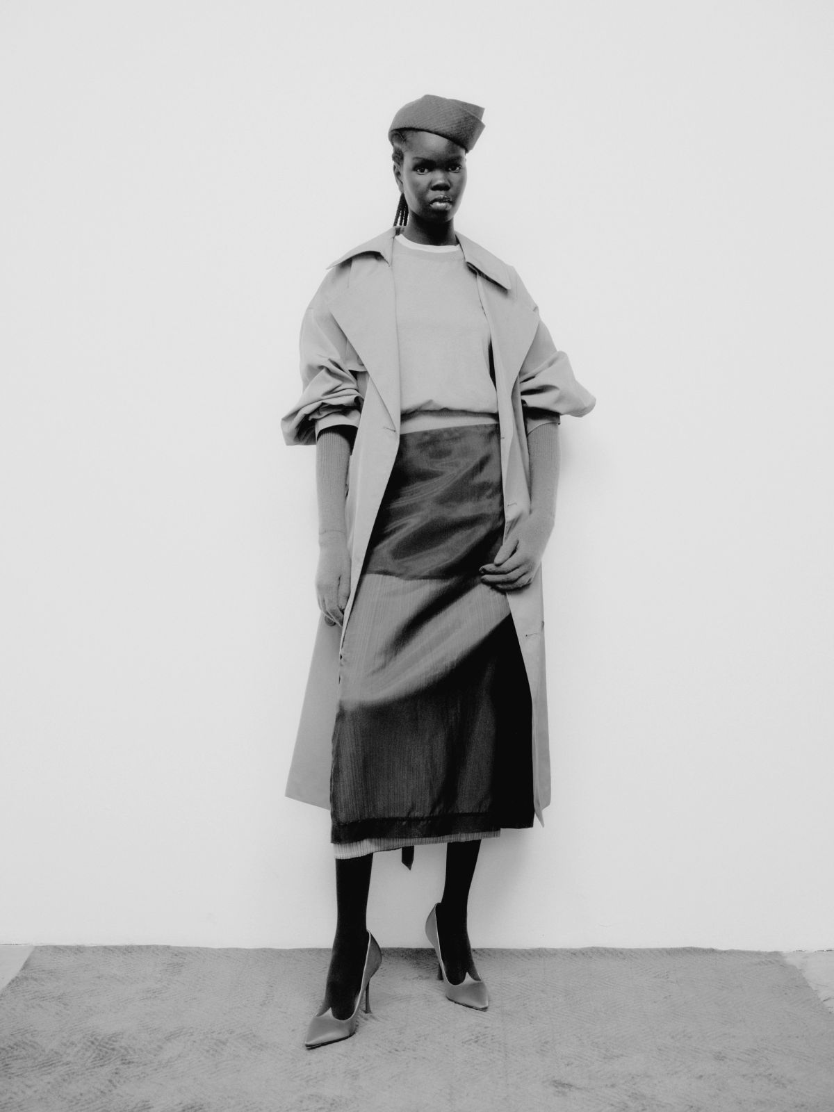 full length outfit of a model wearing different layers and a hat