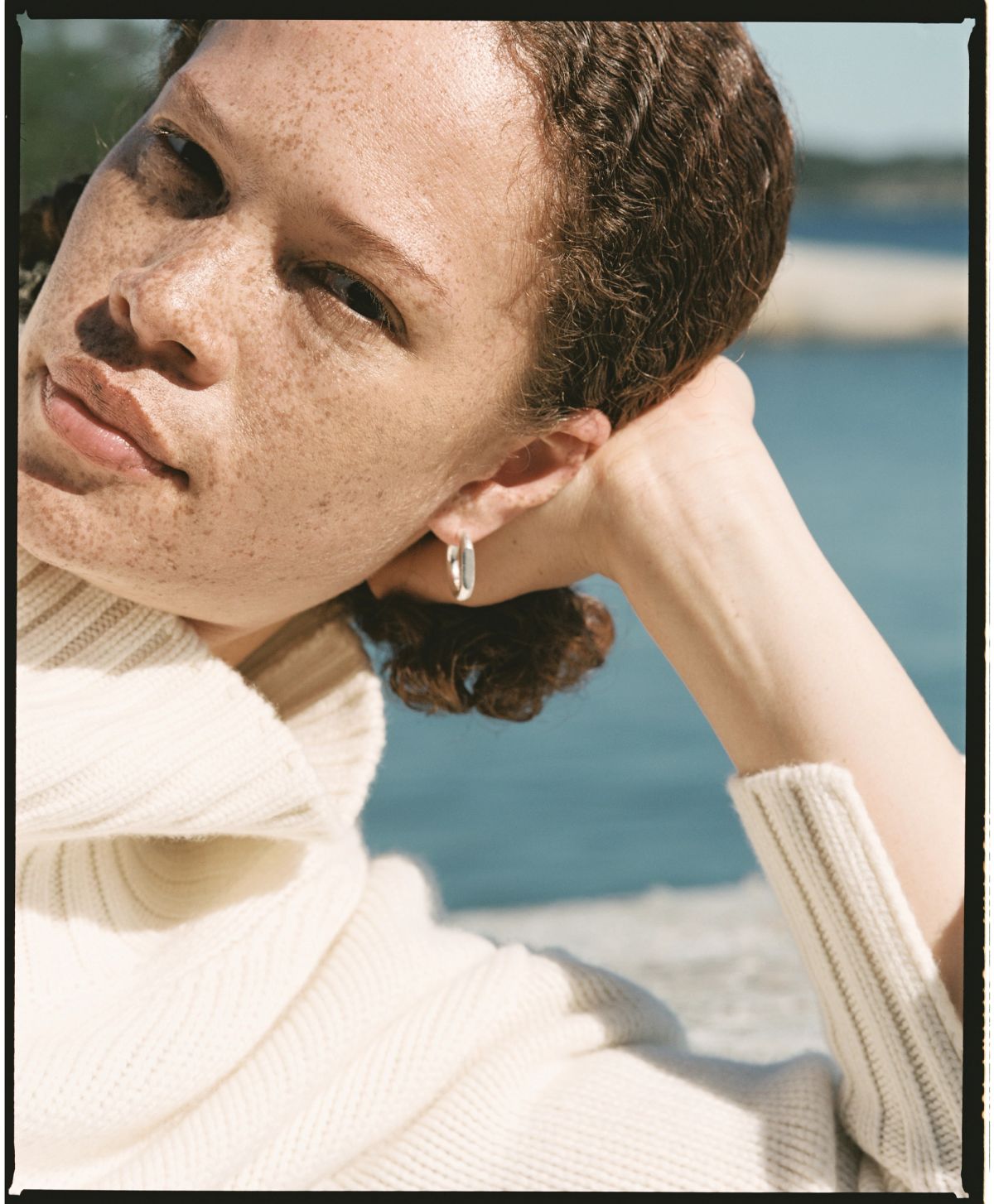 cropped shot of model by sea wearing a jumper