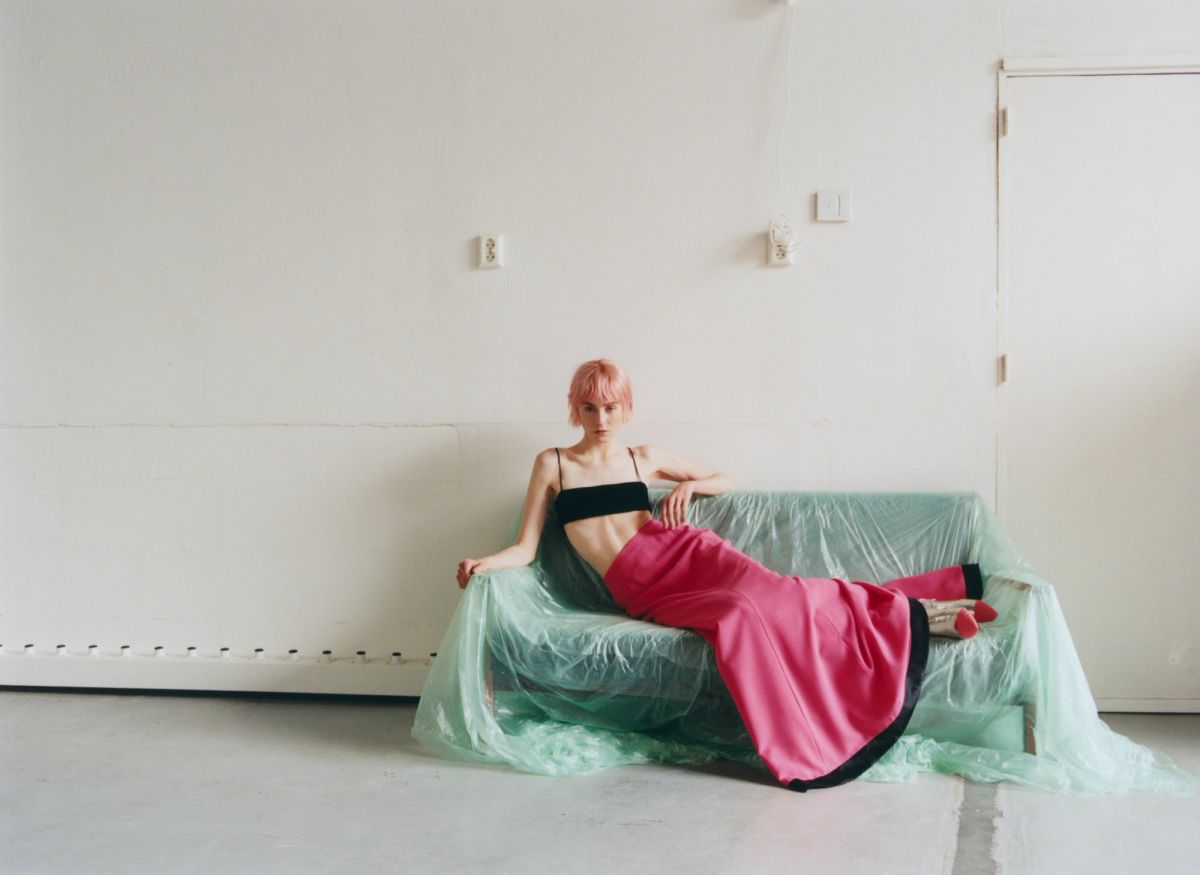 women lying on blue plastic covered sofa wearing pink and black