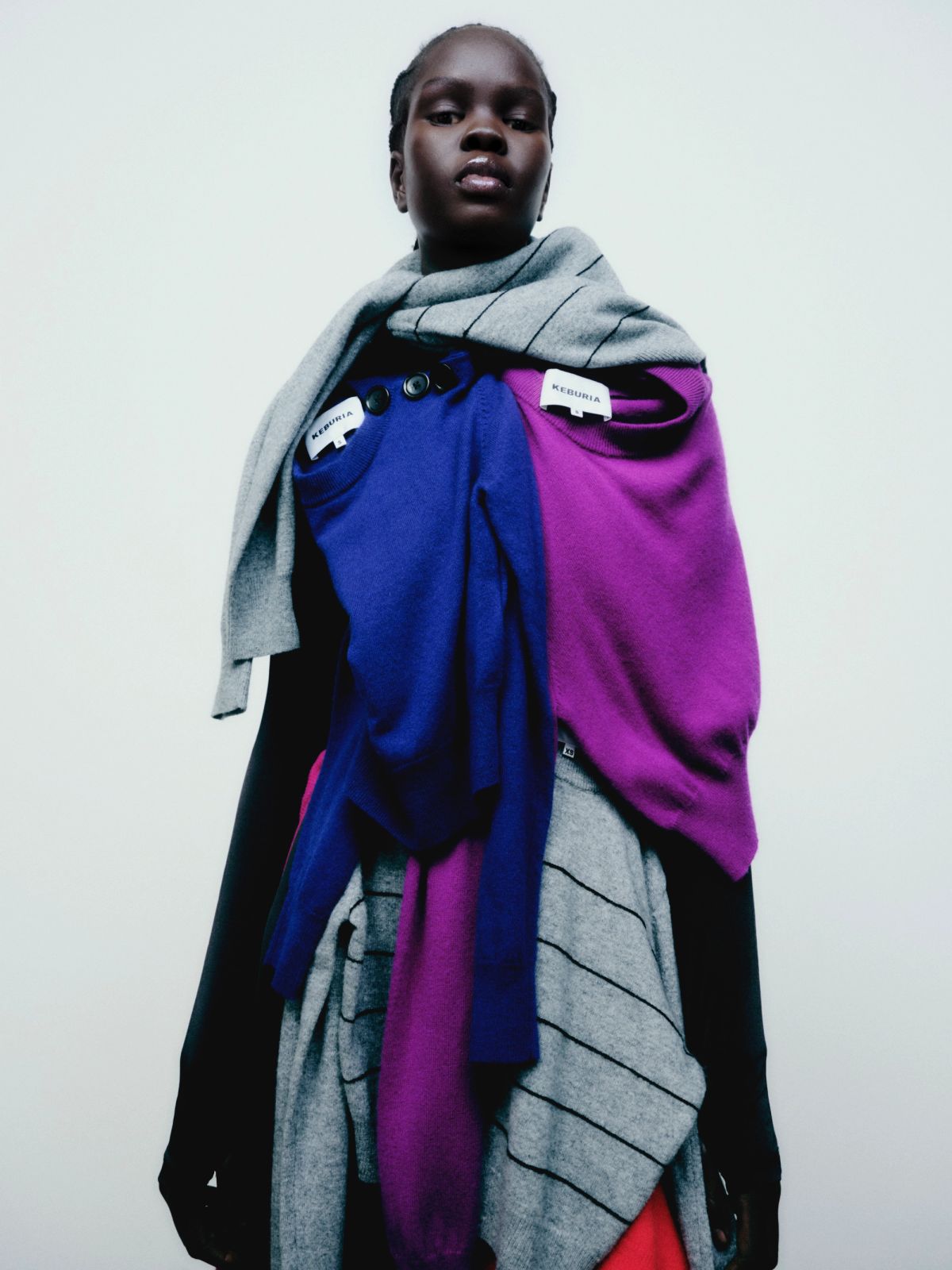 model wearing lots of colourful jumpers