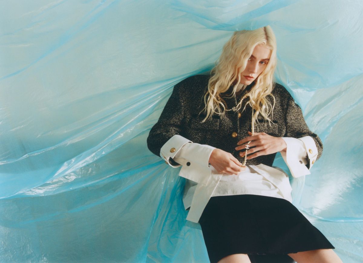 women leaning on a blue plastic sheet wearing a tweed suit