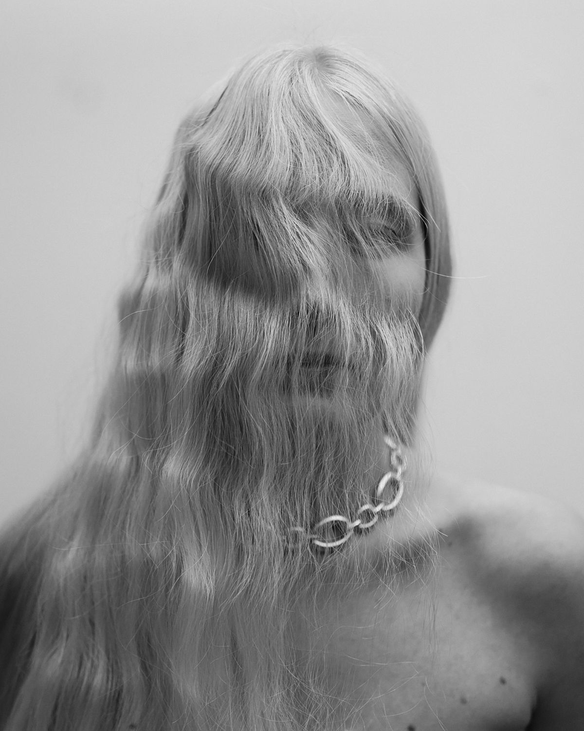 blonde wavy hair covers a models face