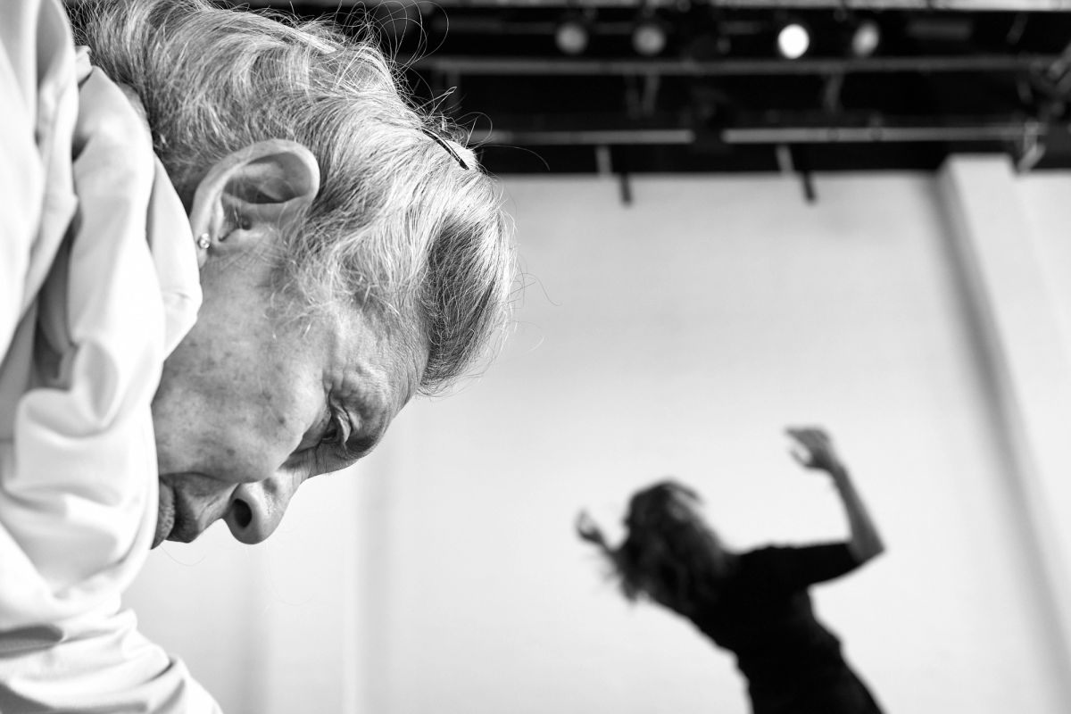 close up of a dancer wearing white with a dancer wearing black in the background