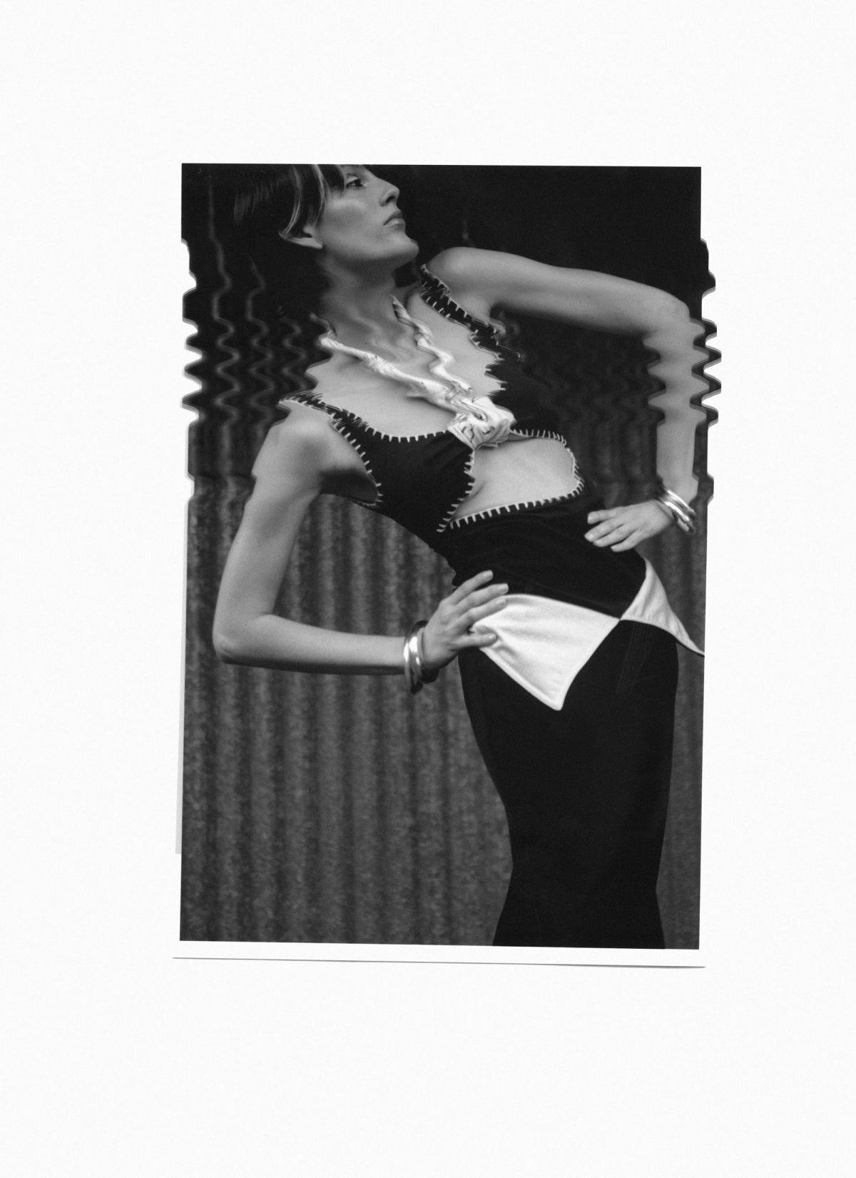 scanned image of a model wearing black and white against a metal backdrop
