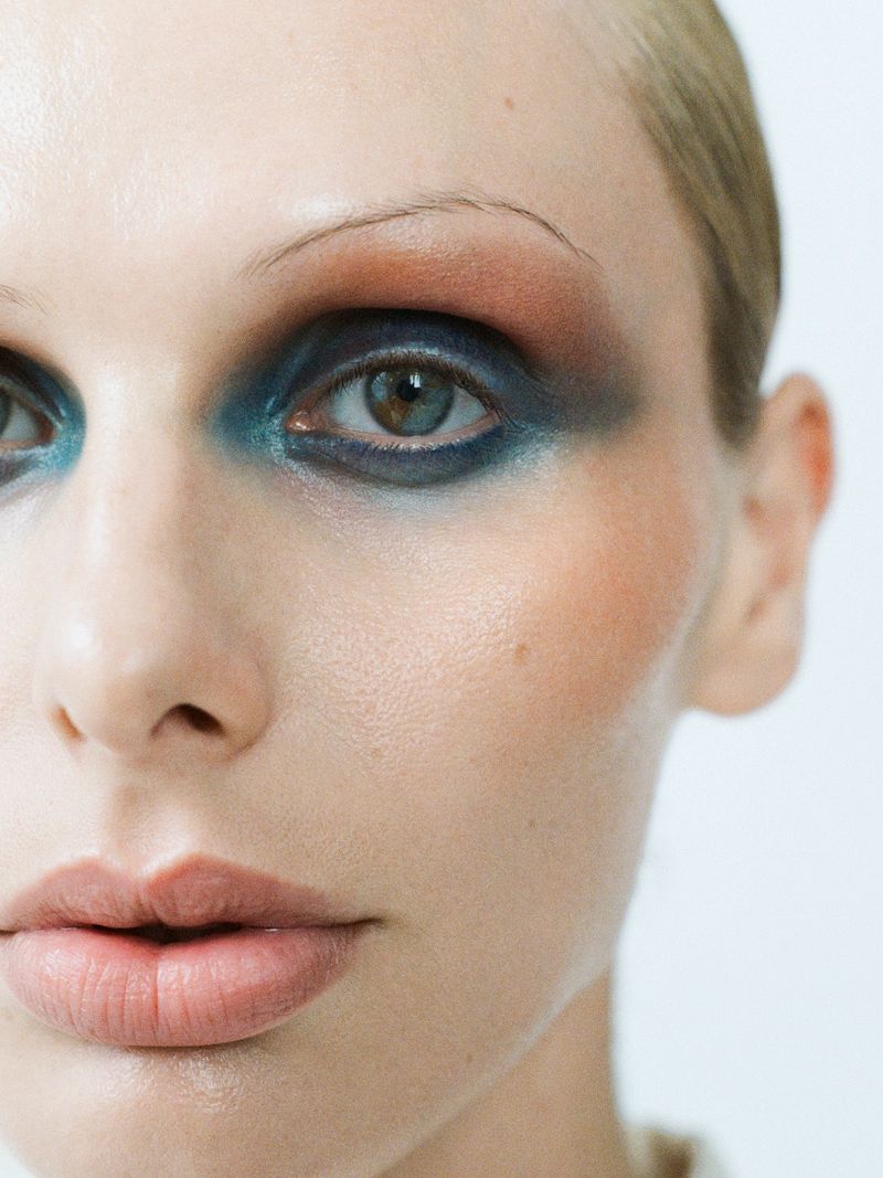 close up of model on white background with blue and orange eyeshadow
