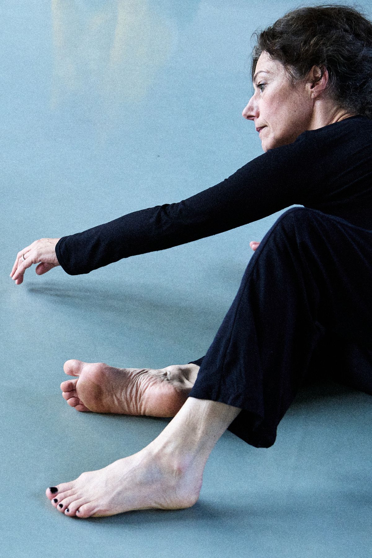croped shot of dancer wearing black sitting on the floor