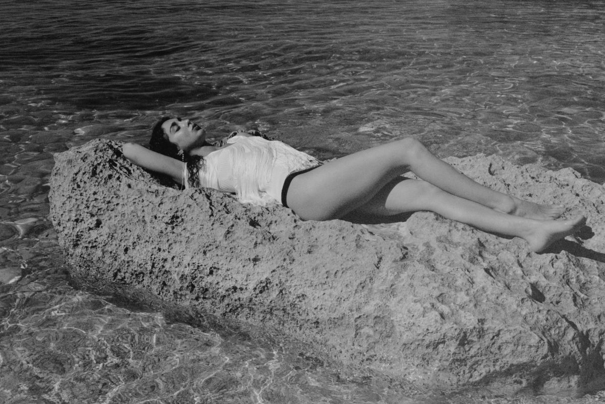 Woman lying on large rock