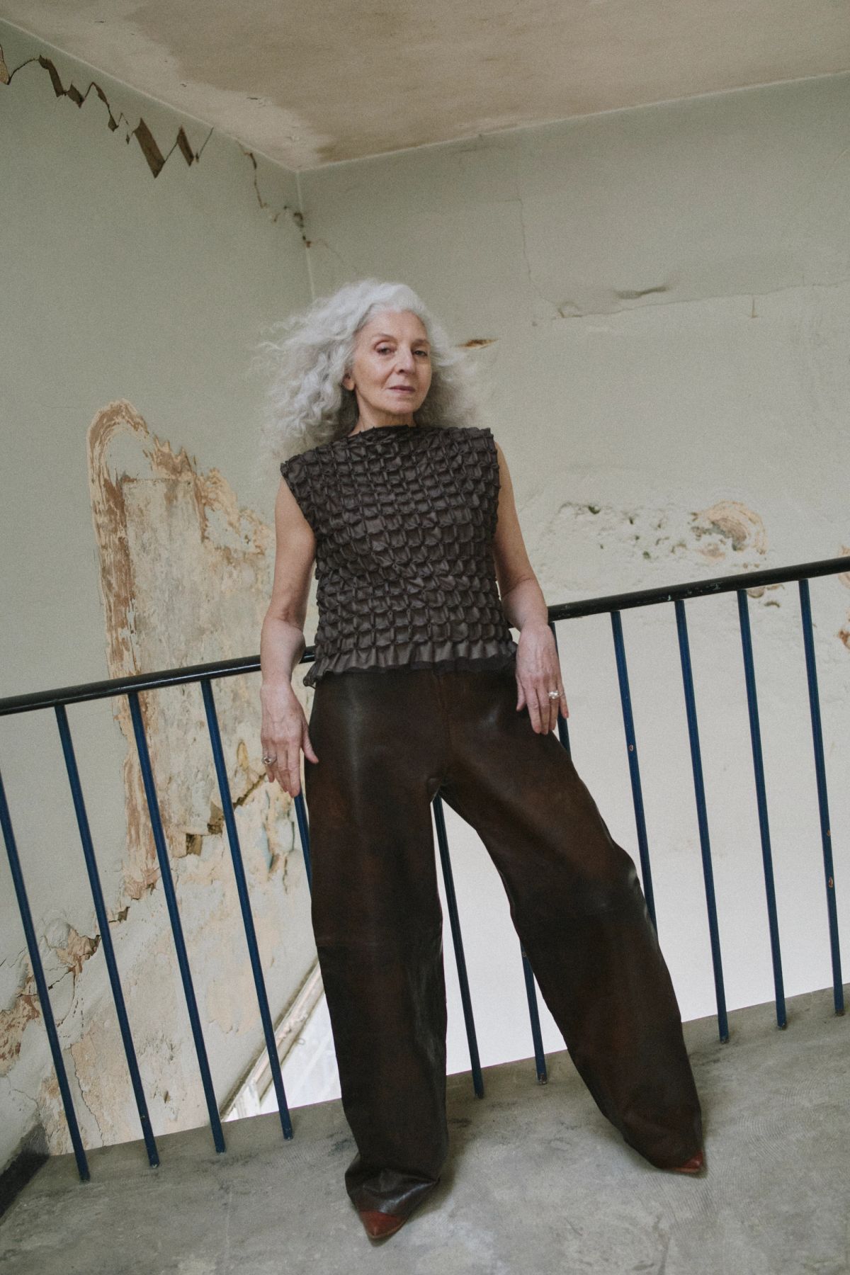 women standing next to black railings wearing black with white hair