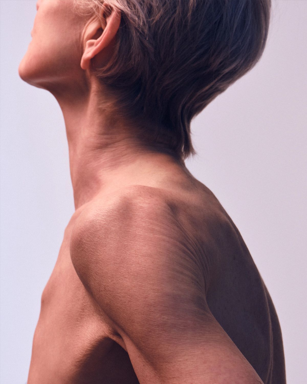 Crop of a women looking off into this distance with bare skin